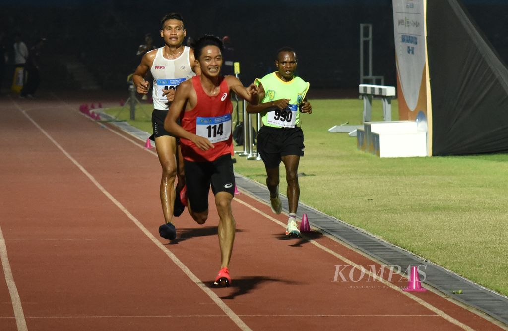 Pelari Bangka Belitung, Robi Syianturi, melakukan selebrasi menjelang finis perlombaan lari 10.000 meter senior putra Kejuaraan Nasional Atletik 2023 di Stadion Sriwedari, Solo, Jawa Tengah, Sabtu (24/6/2023). Robi meraih emas dengan waktu 29 menit 59,47 detik. 