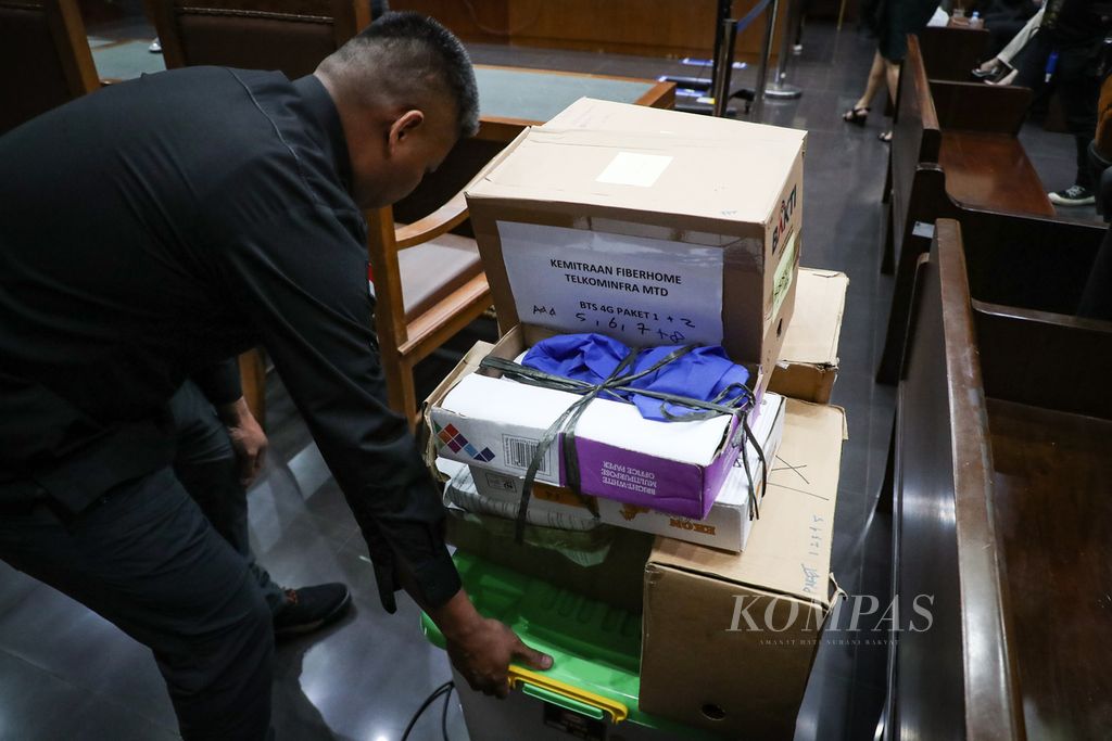 Petugas membawa barang bukti dalam sidang kasus dugaan korupsi pembangunan menara BTS 4G Bakti Kemenkominfo di Pengadilan Tindak Pidana Korupsi Jakarta, Selasa (1/8/2023). 