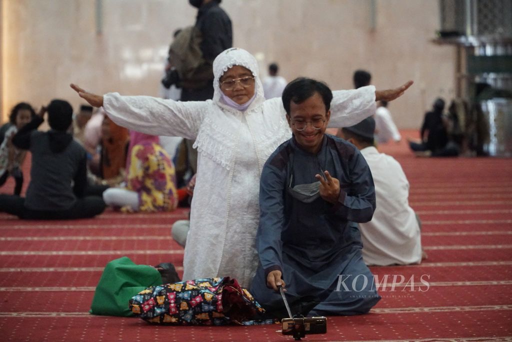 Jemaah berswafoto seusai menjalankan shalat Idul Fitri di Masjid Istiqlal, Jakarta, Senin (2/5/2022). Shalat Id di masjid ini kembali semarak setelah dua tahun terakhir ditiadakan akibat pandemi Covid-19.