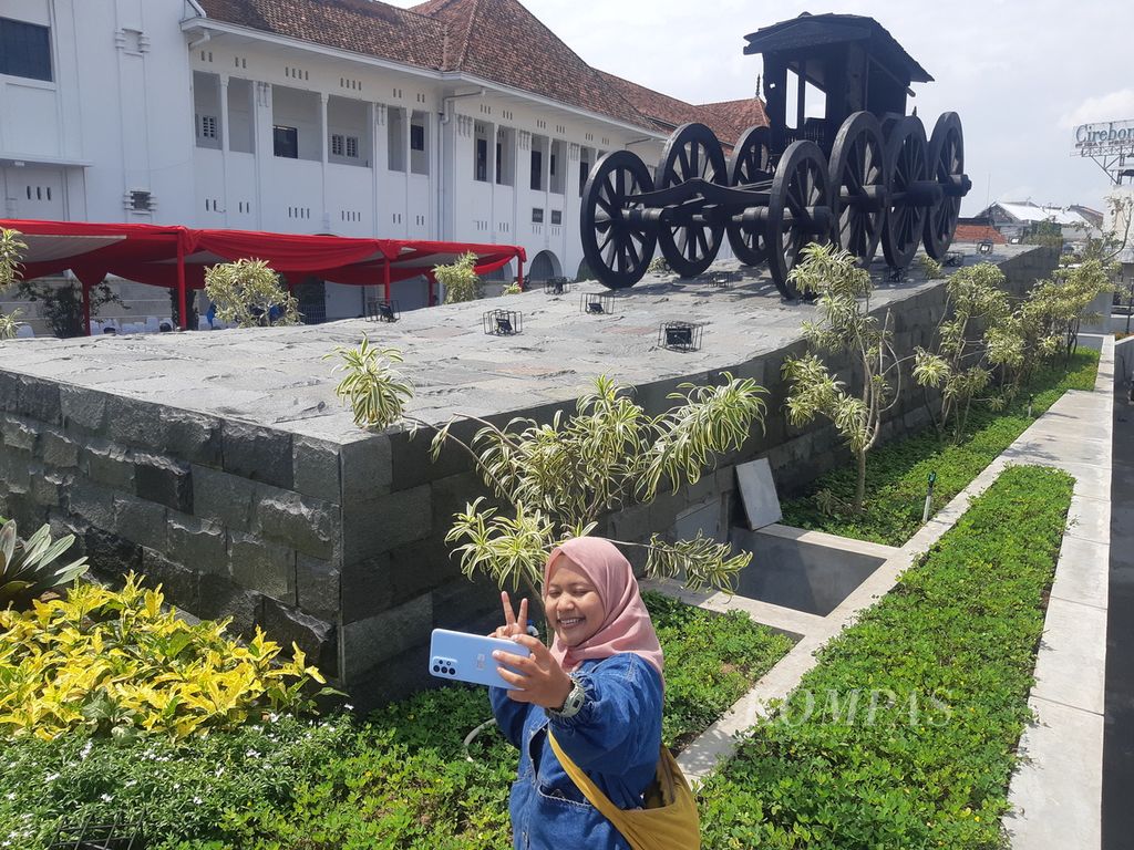 Warga berfoto di depan replika Pedati Gede di kawasan British American Tobacco (BAT), Kota Cirebon, Jawa Barat, Senin (12/12/2022). Replika itu menyerupai Pedati Gede Pekalangan yang dibangun Mbah Kuwu Cirebon pada 1445-1479.