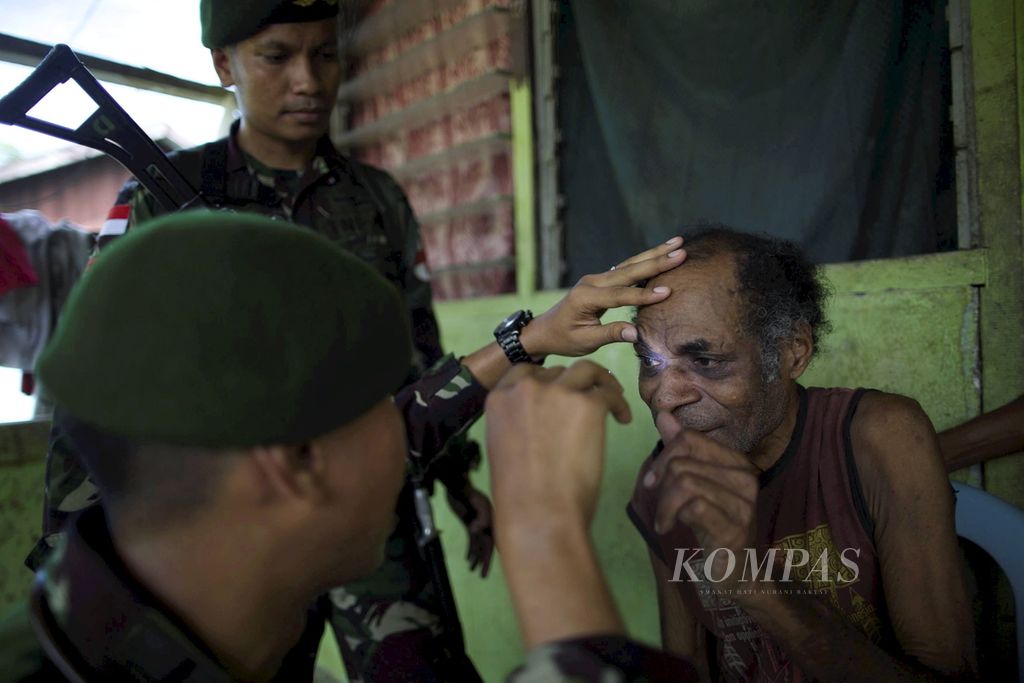 Dokter dari Satgas Pamtas RI-PNG dari Yonif Para Raider 432/Kostrad mengecek warga yang sakit di Distrik Muara Tami, Jayapura, Papua, Senin (17/7). 
