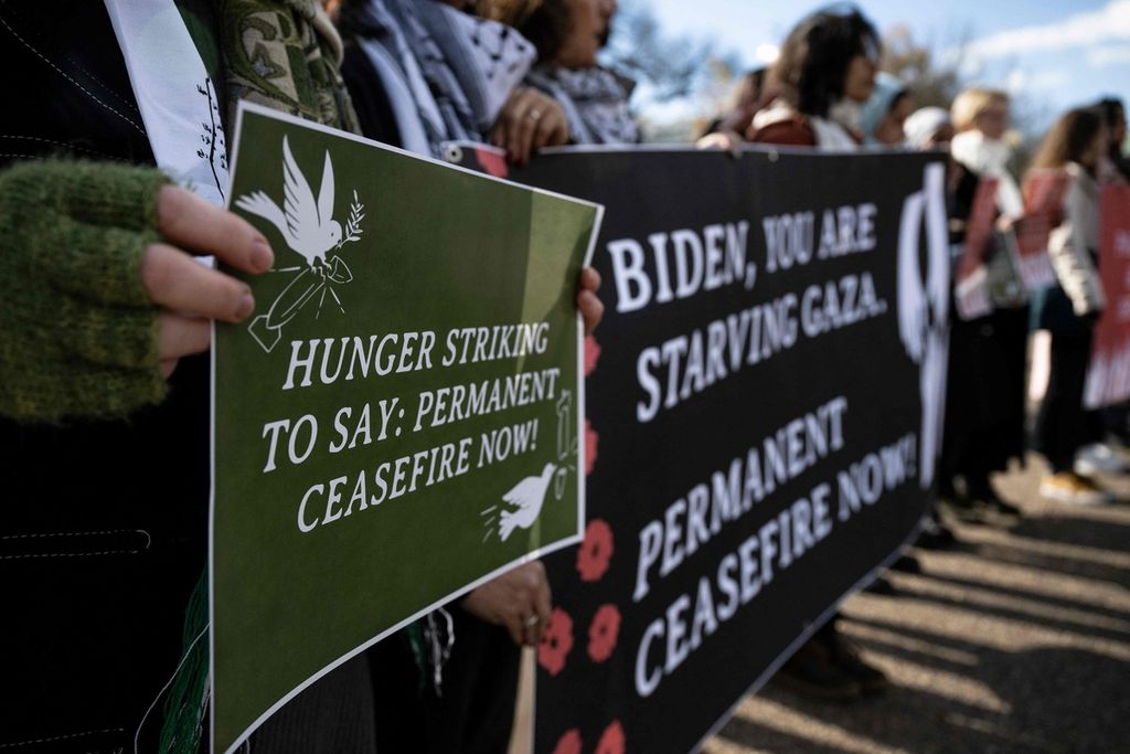 Para demonstran memegang spanduk saat aktris dan aktivis Amerika Serikat, Cynthia Nixon (tidak terlihat), bergabung dengan legislator negara dan aktivis, meminta gencatan senjata permanen di Gaza, di depan Gedung Putih di Washington DC, AS, pada 27 November 2023. 
