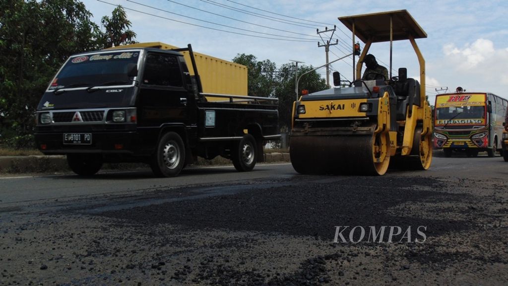 Pekerja menambal jalan berlubang di jalur pantura, tepatnya di daerah Larangan, Kabupaten Indramayu, Jawa Barat, pada Februari 2017.