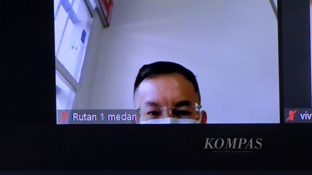 Terdakwa bos judi <i>online</i> Jonni alias Apin BK (42) mendengarkan melalui video konferensi putusan Majelis Hakim Pengadilan Negeri Medan, Sumatera Utara, Selasa (27/6/2023). Apin dijatuhi vonis tiga tahun penjara dan denda Rp 100 juta. 