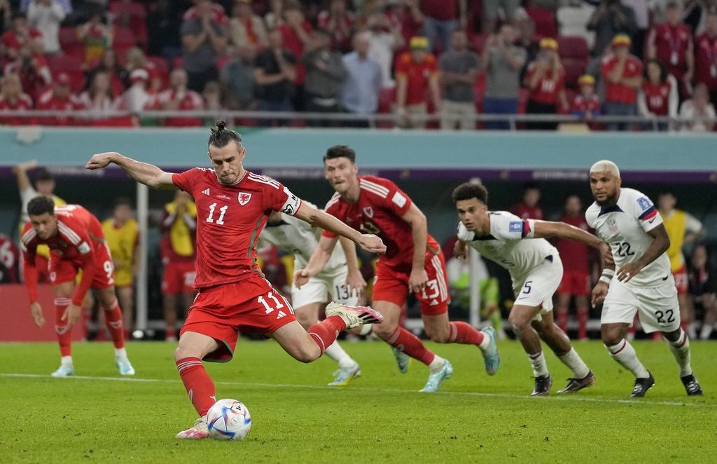 Pemain Wales, Gareth Bale, mencetak gol ke gawang AS melalui tendangan penalti pada laga penyisihan Grup B Piala Dunia atar 2022 di Stadion Ahmad Bin Ali, Doja, Qatar, Senin (21/11/2022). Laga itu berakhir imbang 1-1.