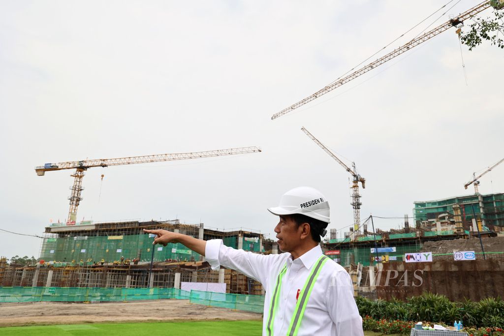 Presiden Joko Widodo dengan latar belakang pembangunan Istana Negara di Ibu Kota Nusantara (IKN), Penajam Paser Utara, Kalimantan Timur, Jumat (22/9/2023).