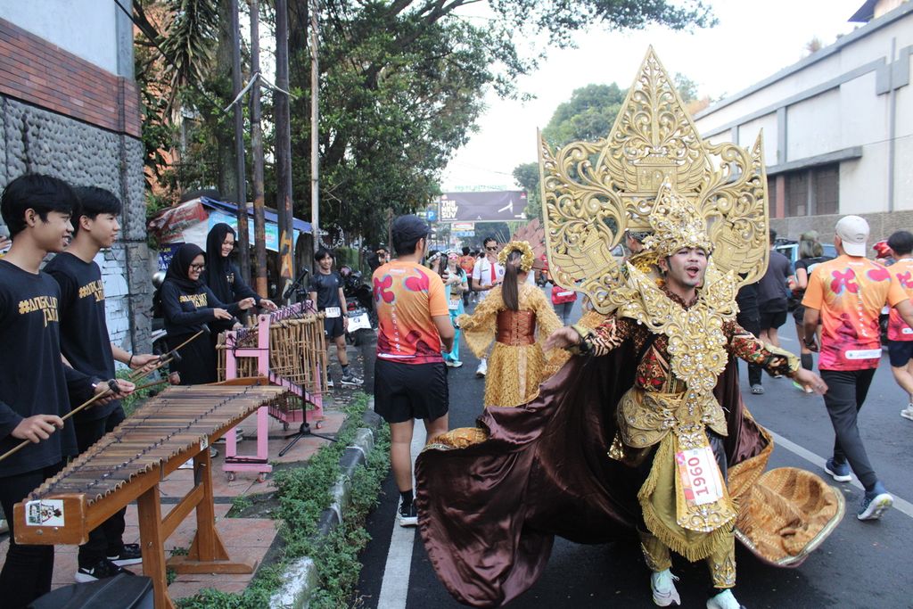 Peserta berkostum dari Bank Jateng Friendship Run turut menari sambil berlari di Jalan Cicendo, Kota Bandung, Jawa Barat, Minggu (4/6/2023).