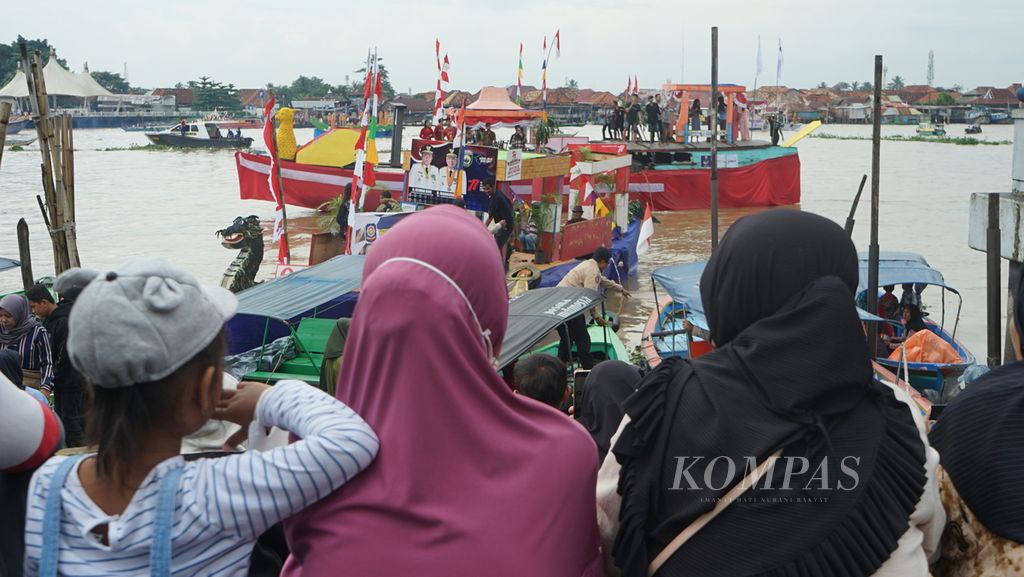 Sejumlah warga Palembang menyaksikan parade perahu hias di pelataran Benteng Kuto Besak Palembang, Sumatera Selatan, Sabtu (20/8/2022). Parade ini merupakan rangkaian dari perayaan Hari Ulang Tahun Ke-77 Republik Indonesia. Acara tahunan ini dihentikan pelaksanaannya dua kali karena pandemi Covid-19.