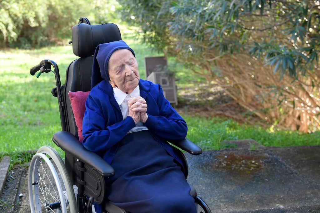 Dalam foto yang diambil pada 10 Februari 2021 ini, Lucile Randon atau yang juga dikenal dengan panggilan Suster Andre berdoa di atas kursi roda menjelang ulang tahunnya ke-117 di sebuah panti wreda di Toulon, Perancis selatan. Ia meninggal dunia dalam usia 118 tahun, Selasa (17/1/2023). 