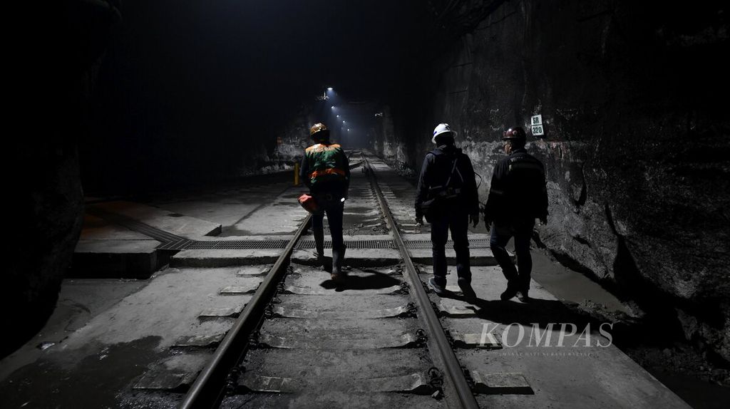 Pekerja melewati jalur kereta tambang bawah tanah Grasberg Blok Cave (GBC) PT Freeport Indonesia di Tembagapura, Timika, Papua, Rabu (1/6/2022). <i>Block caving</i> merupakan cara penambangan bawah tanah dengan efisiensi sumber daya yang tinggi untuk melakukan penambangan.