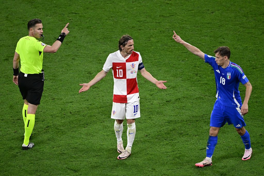 Luka Modric terlibat perdebatan dengan pemain Italia, Nicolo Barella, dan wasit asal Belanda, Danny Makkelie, pada pertandingan Grup B antara Kroasia dan Italia di Stadion Leipzig, Leipzig, Jerman, pada 24 Juni 2024. 