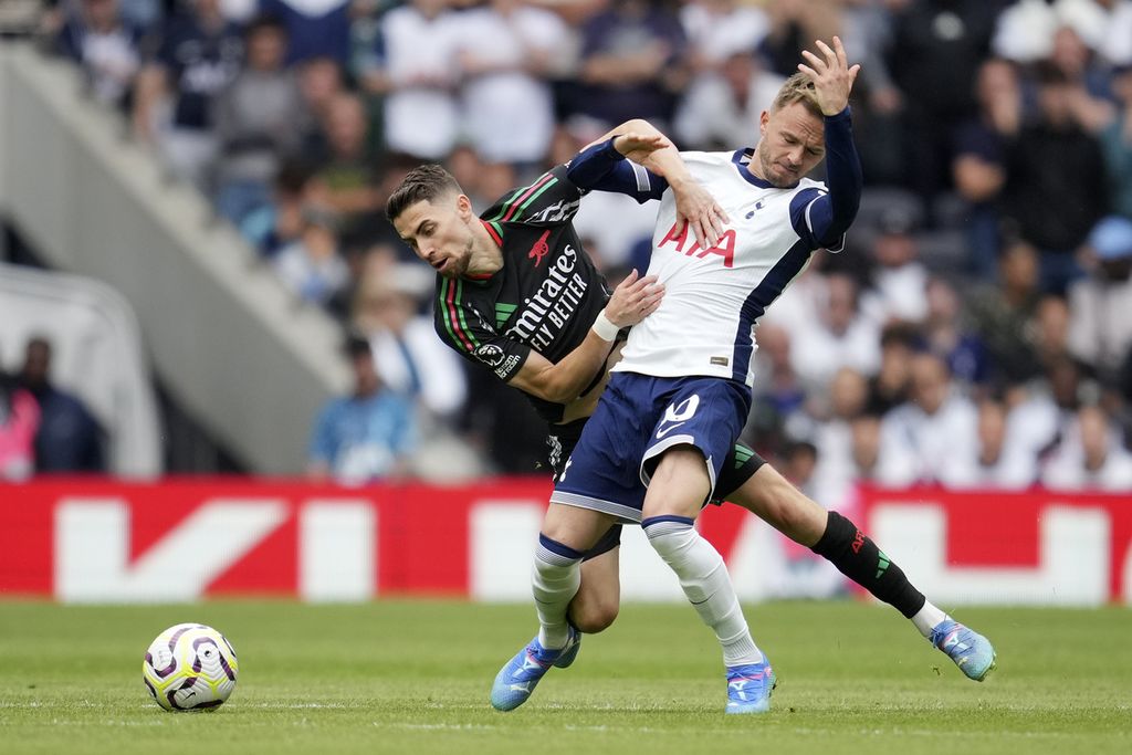 Gelandang Tottenham Hotspur, James Maddison (depan), berebut bola dengan gelandang Arsenal, Jorginho, pada laga Liga Inggris di London, Minggu (15/9/2024).