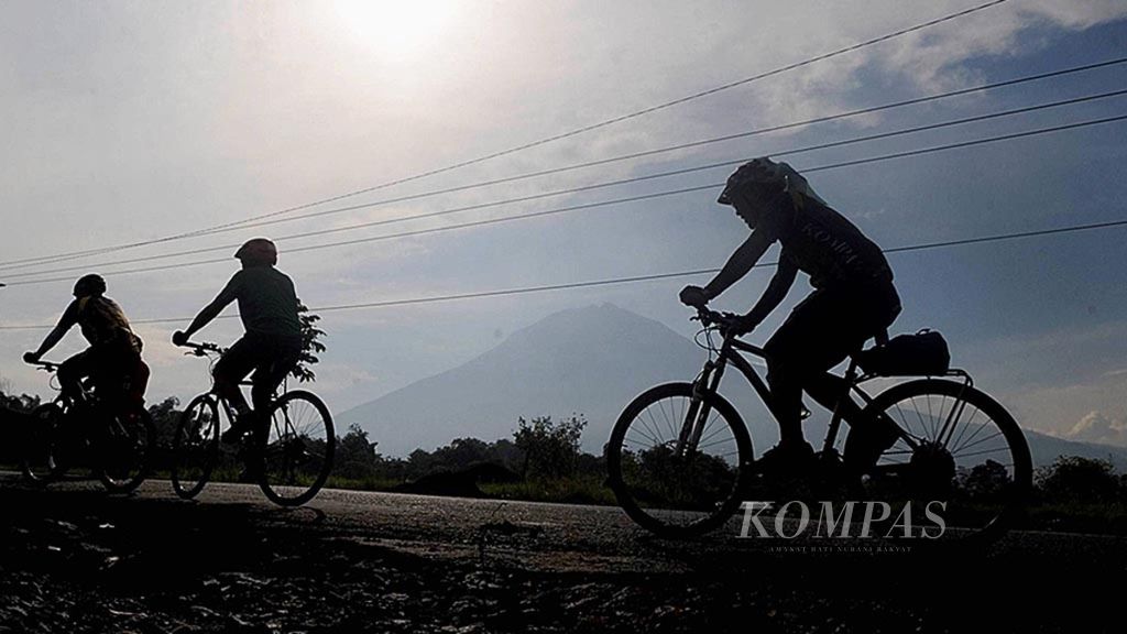 Pesepeda melintasi Gunung Sumbing dan Sindoro di Kledung, Kabupaten Wonosobo, Jawa Tengah, Maret 2017.