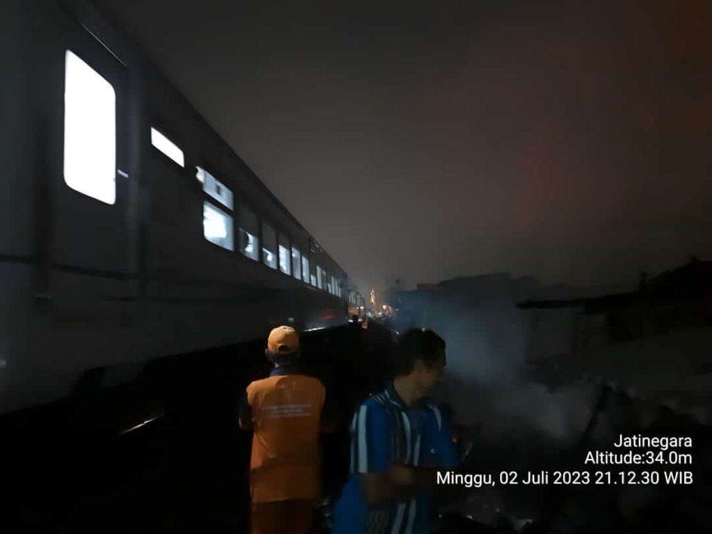 Kereta rel listrik melintas di jalur kereta api wilayah Jatinegara, Jakarta Timur, Minggu (2/7/2023) malam. Kereta melintas seusai penanganan kebakaran di dekat rel dipadamkan petugas.