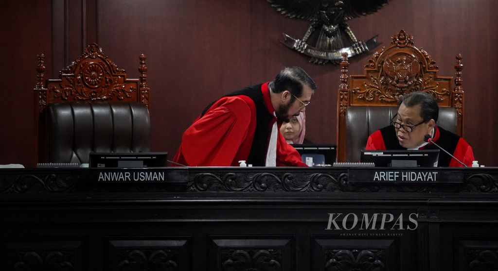 Hakim Konstitusi Anwar Usman (kiri) meminta izin ke kamar kecil kepada Hakim Konstitusi Arief Hidayat saat digelar sidang PHPU pemilihan legislatif di Mahkamah Konstitusi, Jakarta, Senin (29/4/2024). 
