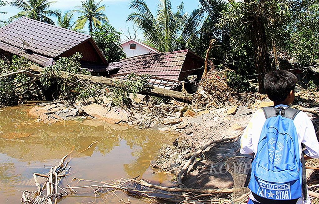 Seorang anak melihat  rumah rusak di Desa Lenggang, Kecamatan Gantung, Belitung Timur, Rabu (19/7). Rumah ini hancur setelah diterjang banjir pada Minggu (16/7) lalu. Pemerintah memperkirakan jumlah rumah yang terendam di Belitung Timur mencapai 3.000 unit.
