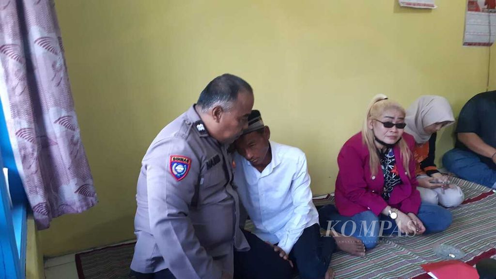 Jakam, ayah dari Oki, tahanan Polresta Banyumas yang tewas, menangis dan memeluk anggota polisi di rumahnya di Purwosari, Baturraden, Banyumas, Jawa Tengah, Senin (5/6/2023).
