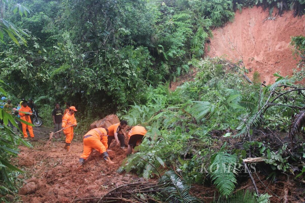 Petugas dari Badan Penanggulangan Bencana Daerah (BPBD) berupaya membersihkan material longsor di Tanuhi, Desa Hulu Banyu, Kecamatan Loksado, Kabupaten Hulu Sungai Selatan, Kalimantan Selatan, Minggu (26/3/2017). 