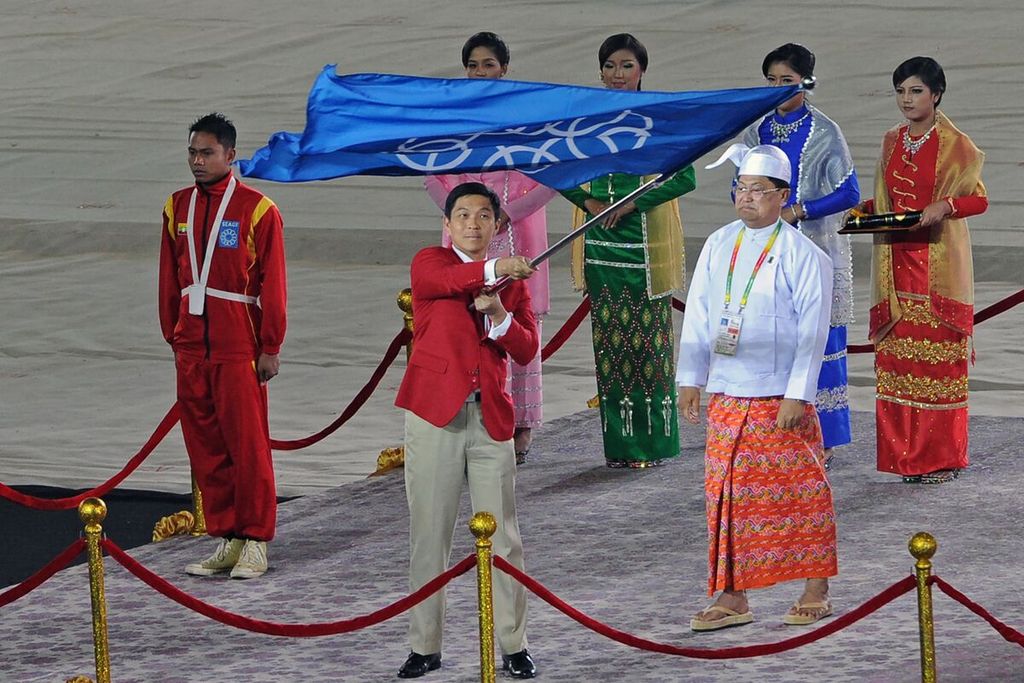 Tan Chuan-jin (tengah), kala menjabat Menteri Tenaga Kerja Singapura, mengibarkan bendera federasi SEA Games seusai penyerahan bendera itu dalam upacara penutupan SEA Games ke-27 di Naypyidaw, Myanmar, 22 Desember 2013. Tan mengundurkan diri dari jabatan Ketua DPR Singapura pada 17 Juli 2023 terkait skandal perselingkuhan. 
