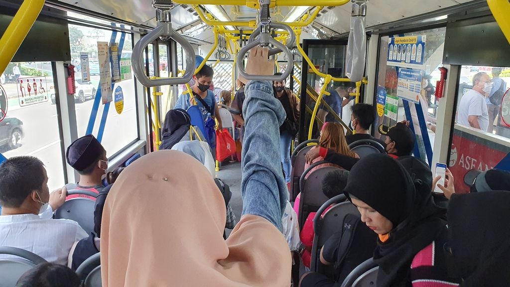 Sejumlah penumpang duduk dan berdiri di dalam bus yang baru mengangkut orang dari Halte TransJakarta, Bundaran HI, Jakarta, Minggu (23/4/2023).  