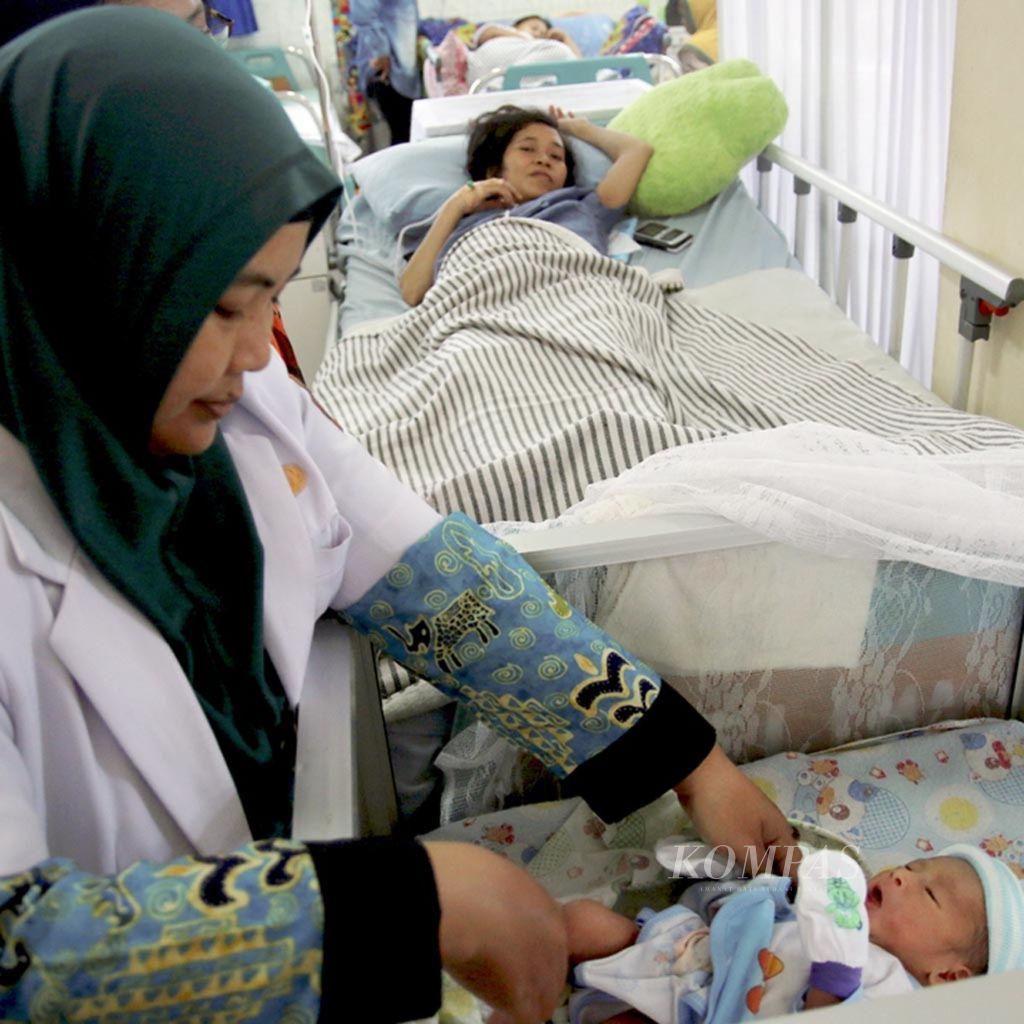 Bayi Arjuna (1 hari) diletakkan di dekat kasur ibunya, Flora Handayani (32), saat bidan memeriksa kondisi ibu dan bayi pascapersalinan di RSUD Abdul Moeloek, Bandar Lampung, Lampung, Sabtu (3/10/2015). Saat itu, Lampung merupakan salah satu provinsi dengan angka kematian ibu melahirkan tertinggi. 