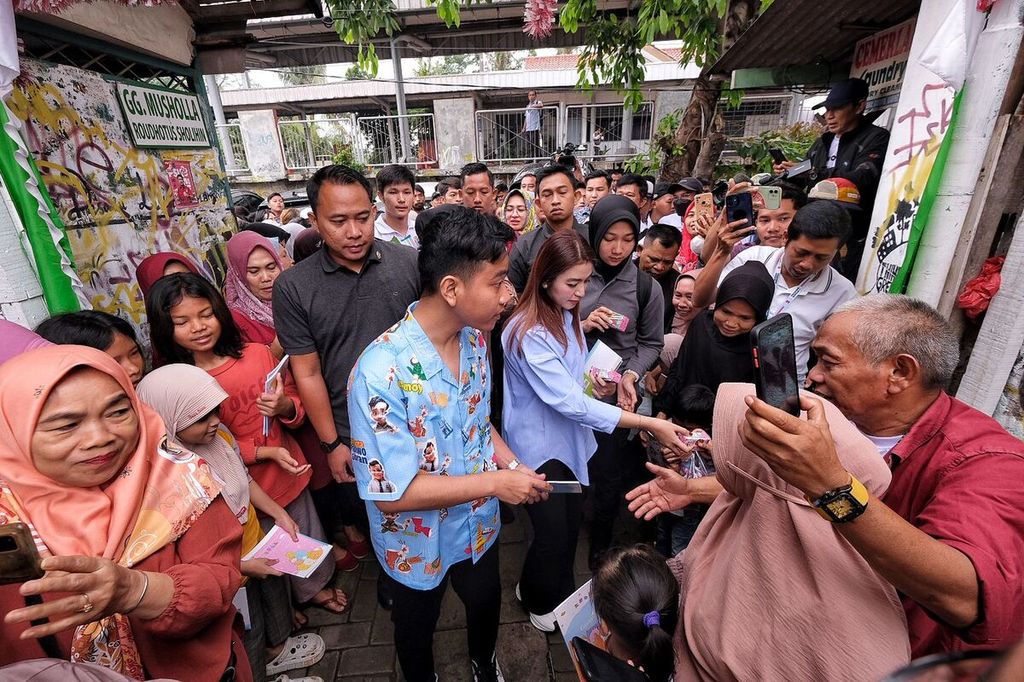 Calon wakil presiden nomor urut 2, Gibran Rakabuming Raka, bersama istrinya, Selvi Ananda, blusukan di Kampung Sawah, Poris Gaga, Tangerang (4/12/2023). Mereka membagikan buku tulis dan susu kepada anak-anak dan ibu-ibu setempat.