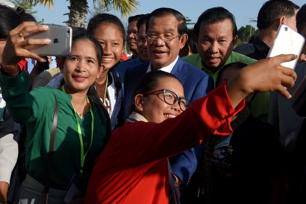 Perdana Menteri Kamboja Hun Sen (tengah) berfoto bersama dengan warga ketika dia menghadiri peluncuran kapal angkutan umum di Phnom Penh, Rabu (1/8/2018). Hun Sen kembali memenangi pemilihan umum Kamboja.