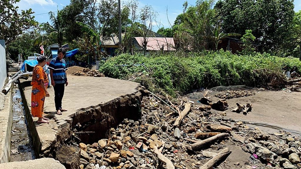 Warga Desa Sampulungan, Kecamatan Galesong Utara, Takalar, Sulawesi Selatan, mengamati jalan yang rusak akibat abrasi, beberapa waktu lalu.