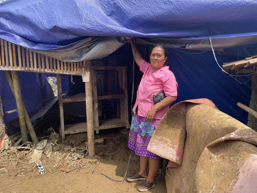 Penyintas gempa CIanjur, Yanti Susanti (43), menunjukkan tendanya di pengungsian Kampung Gununglanjung, Desa Cijedil, Kecamatan Cugenang, Kabupaten Cianjur, Jawa Barat, yang sempat terendam banjir pada Senin (20/3/2023).