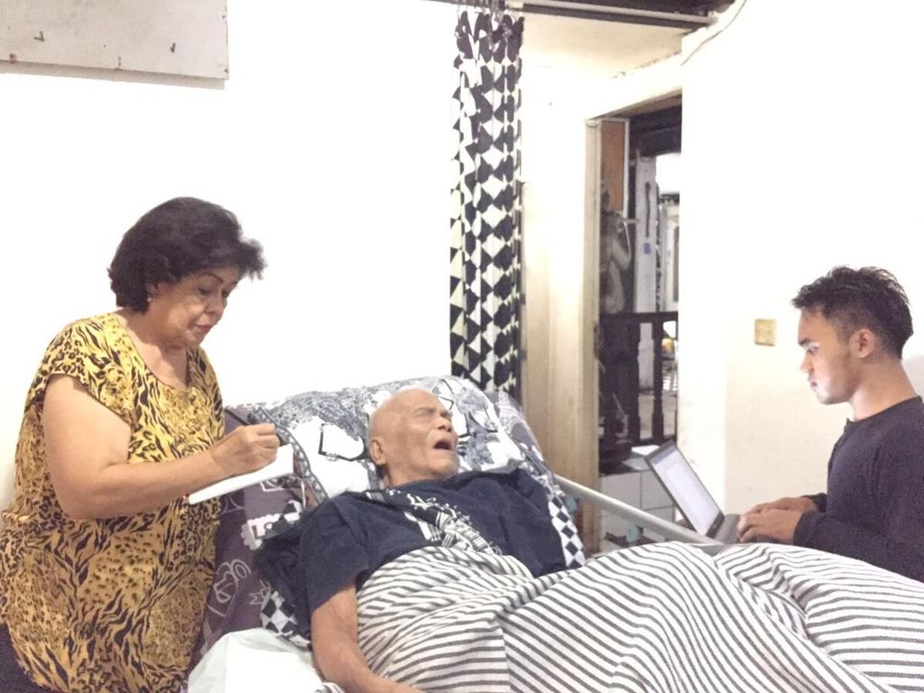 Sastrawan Remy Sylado (79) meski terbaring dengan kondisi lemah tetap mendiktekan karyanya kepada istri dan anaknya, Rabu (2/3/2022), di Jakarta.