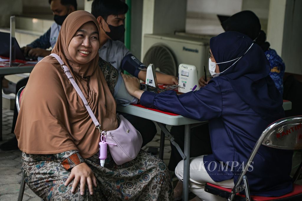Tenaga kesehatan memeriksa tekanan darah warga yang akan menjalani vaksinasi di Kantor Dinas Kesehatan DKI Jakarta, Selasa (19/12/2023). 