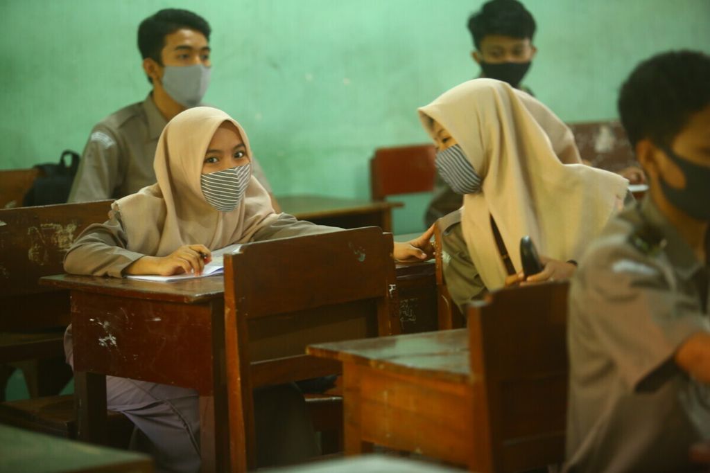 Siswa kelas X mengikuti pelajaran dengan tetap mengenakan masker ketika sekolah tatap muka di SMA Negeri 1 Giri Banyuwangi, Senin (16/11/2020). Minggu ini, 7.861 siswa dari total 36.444 siswa SMA/SMK sederajat di Banyuwangi mengikuti uji coba sekolah tatap muka tahap II.