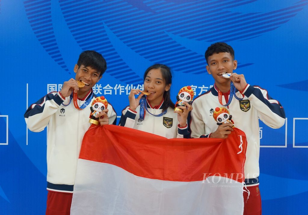 Tiga atlet wushu Indonesia, yaitu Pandu Pratama (kiri), Tharisa Dea Florentina, dan Bintang R Nada Guitara, memamerkan medali Universiade Chengdu, China, yang mereka peroleh pada Kamis (3/8/2023). Pandu dan Tharisa meraih emas, sementara Bintang mendapat perak.