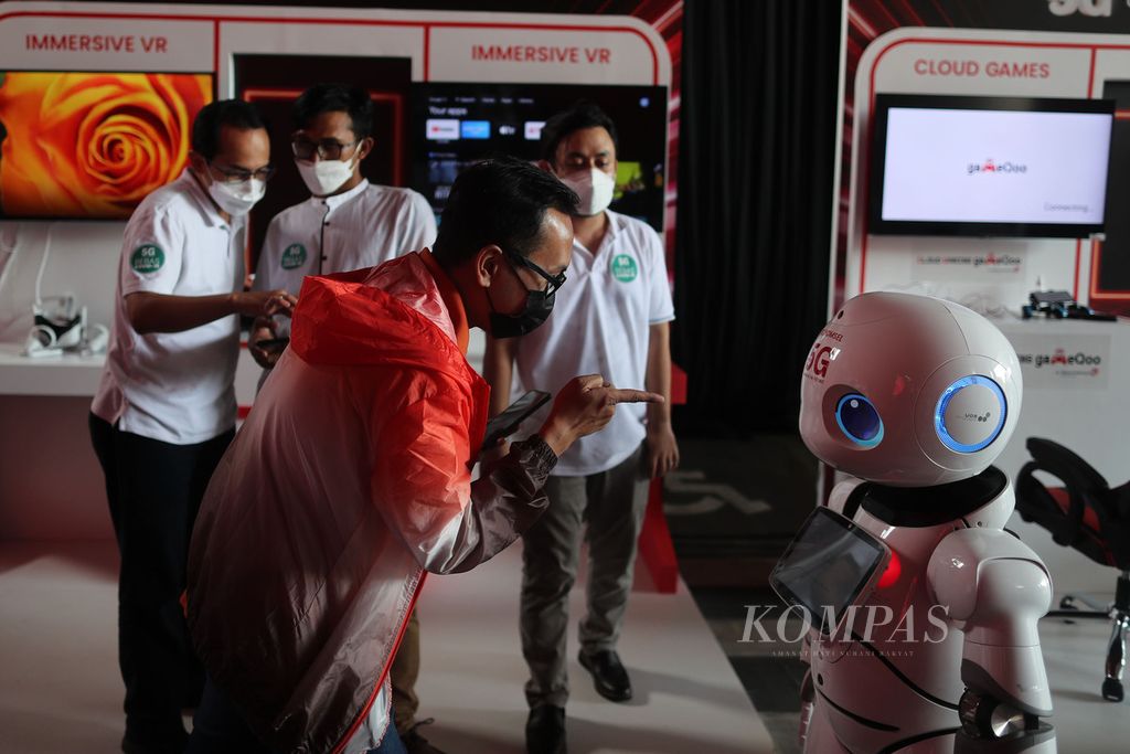 Pengunjung mencoba berkomunikasi dengan UU Robot yang dijalankan melalui jaringan 5G saat peluncuran layanan 5G Telkomsel di Jakarta, Kamis (27/5/2021). Telkomsel secara resmi meluncurkan layanan 5G, dan pada tahap pertama komersialisasi layanannya tersedia di sejumlah titik di sembilan kota.
