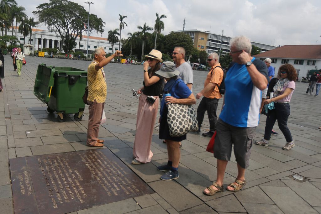Pemandu menjelaskan kepada wisatawan mancanegara (wisman) di Lapangan Museum Fatahillah, Kota Tua, Jakarta Barat, Senin (20/1/2020). 