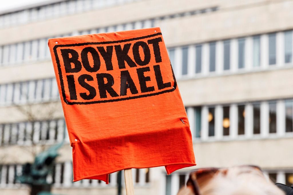 Peserta demonstrasi mengangkat spanduk bertuliskan &quot;Boikot Israel&quot; saat unjuk rasa di Kopenhagen, Denmark, Minggu (5/5/2024).