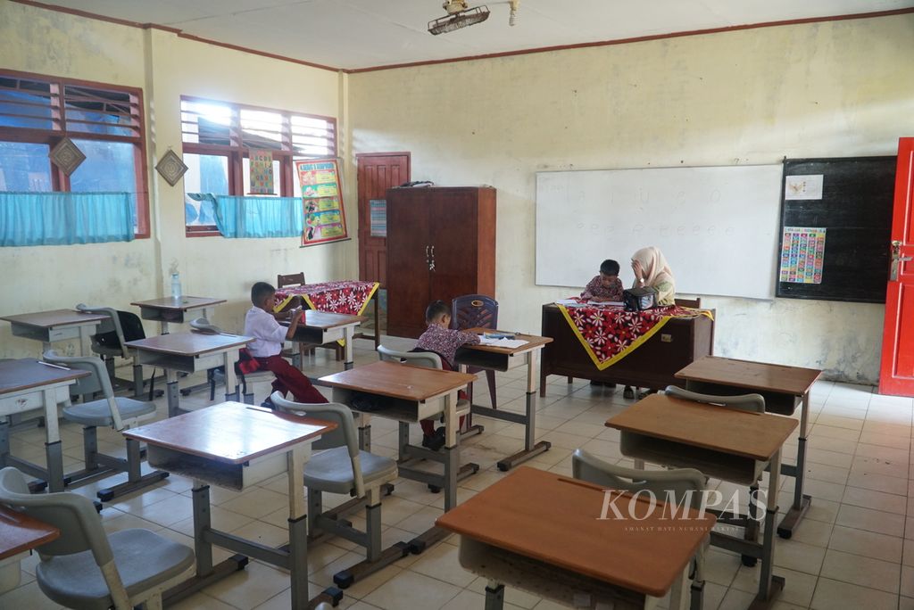Guru mengajar cara menulis huruf kepada tiga siswa kelas I di SD Negeri 23 Lolong, Kecamatan Padang Utara, Kota Padang, Sumatera Barat, Kamis (13/7/2023). 