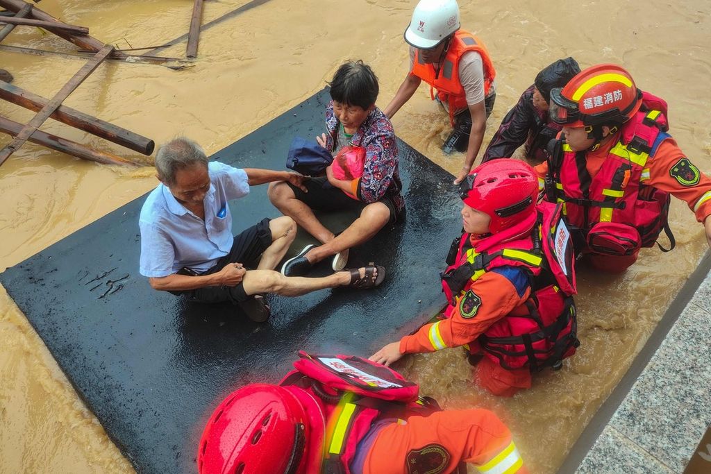 Tim penyelamat mengevakuasi warga menggunakan rakit karet dari wilayah Quanzhou, Provinsi Fujian, China yang terdampak topan Doksuri pada Jumat (28/7/2023).