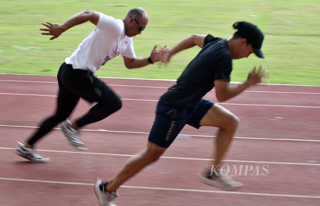 Pelari putri muda Indonesia, Valentin Vanesa Lonteng, mencoba adu kecepatan dengan legenda lari Indonesia Suryo Agung Wibowo di sela latihan di Stadion Madya Senayan, Jakarta, Senin (31/10/2022). 