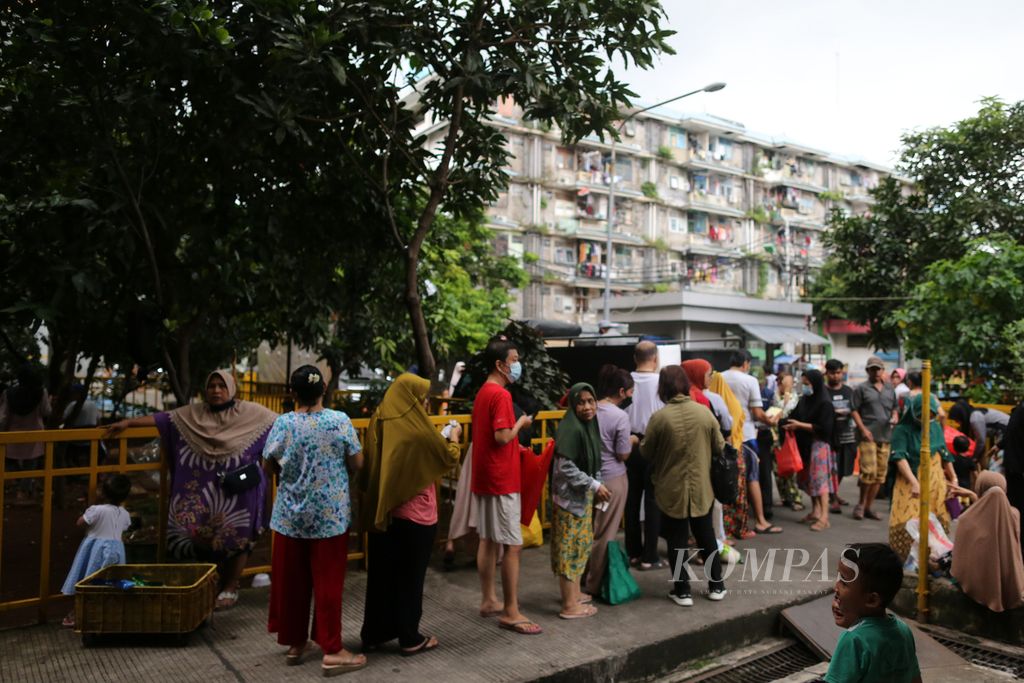 Warga Rumah Susun (Rusun) Tambora, Jakarta Barat, antre untuk berbelanja bahan pangan dengan harga lebih murah pada program pangan bersubsidi di halaman rusun, Rabu (8/6/2022).