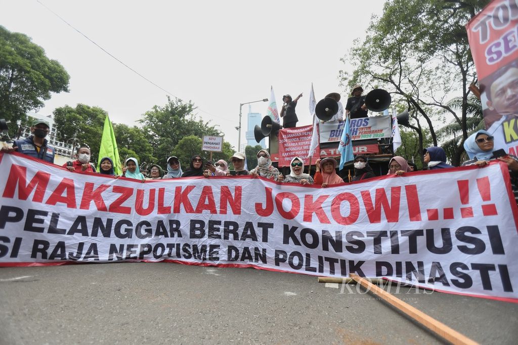 Demonstran membentangkan spanduk berisi tuntutan mereka di depan Kantor Komisi Pemilihan Umum (KPU), Jakarta, Rabu (21/2/2024). Peserta aksi yang tergabung dalam Poros Buruh menggelar demonstrasi di depan Kantor KPU. Mereka meminta pertanggungjawaban KPU dan Bawaslu sebagai lembaga penyelenggara dan pengawas Pemilu 2024 atas terjadinya berbagai permasalahan kecurangan yang terjadi dalam pelaksanaan Pemilu 2024. Selain itu, mereka juga menyurakan pemakzulan Presiden Joko Widodo. Polisi mengerahkan 1.758 personel untuk berjaga di KPU dan Bawaslu. Akibat demonstrasi tersebut, Jalan Imam Bonjol ditutup total. 