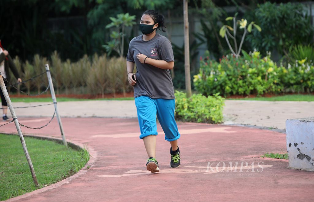 Seorang perempuan berolahraga di Taman Kebagusan I Kebagusan, Jakarta Selatan, Kamis (16/7/2020). Berjalan kaki merupakan salah satu aktivitas fisik yang mudah dilakukan untuk meningkatkan kesehatan seseorang.