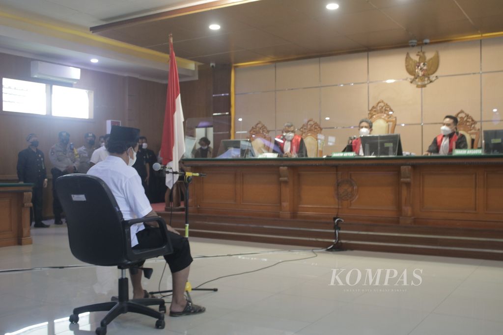 Terdakwa kekerasan seksual terhadap belasan santri di Bandung, Herry Wirawan (rompi merah), berdiskusi dengan tim penasihat hukumnya di tengah persidangan di Pengadilan Negeri Kelas 1A Khusus Bandung, Jawa Barat, Selasa (15/2/2022).