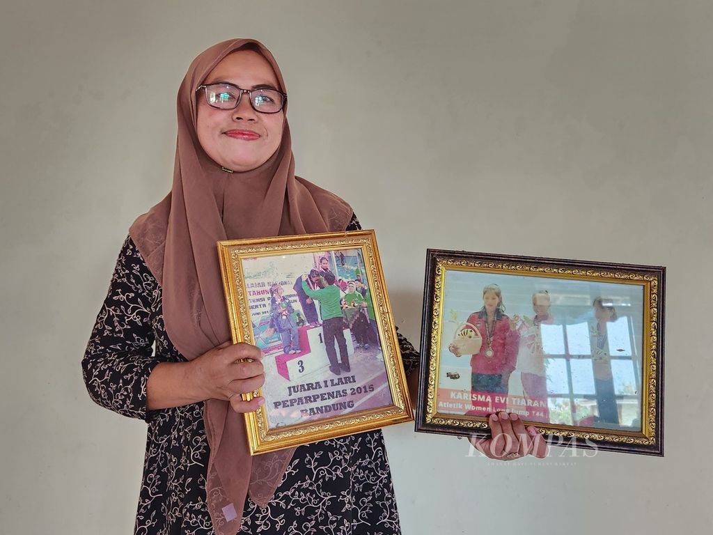 Istikomah, ibu dari Karisma Evi Tiarani, menunjukkan foto putrinya sewaktu memenangi lomba semasa awal meniti jejak menjadi atlet, di tempat tinggalnya, Kabupaten Boyolali, Jawa Tengah, Rabu (22/5/2024). Karisma Evi merupakan sprinter andalan NPC Indonesia yang telah mengukir sederet prestasi. 