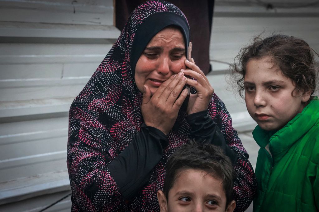 Wanita pengungsi menangis sambil menelepon saudaranya seusai shalat Idul Fitri di kamp pengungsian di Rafah, selatan Jalur Gaza, Rabu (10/4/2024). 