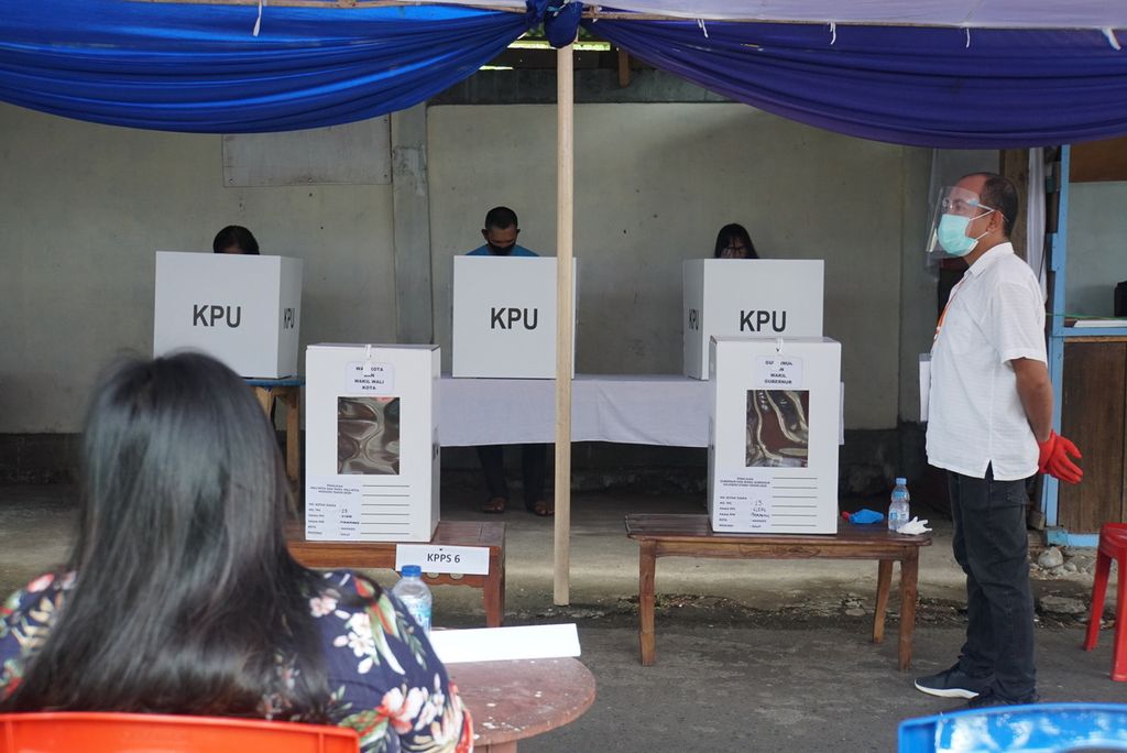 Anggota KPPS di TPS 013 Kleak, Malalayang, Manado, Sulawesi Utara, mengenakan alat pelindung diri saat bertugas pada hari pemungutan suara, Rabu (9/12/2020). Pilkada 2020 di Sulawesi Utara diikuti 1,83 juta pemilih di 5.809 TPS.