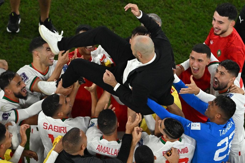 Pemain Maroko merayakan keberhasilan mereka lolos ke fase grup bersama Pelatih Walid Regragui usai mengalahkan Kanada, 2-1, dalam penyisihan Grup F di Stadion Al-Thumama, Doha, Qatar, Kamis (1/12/2022) malam.