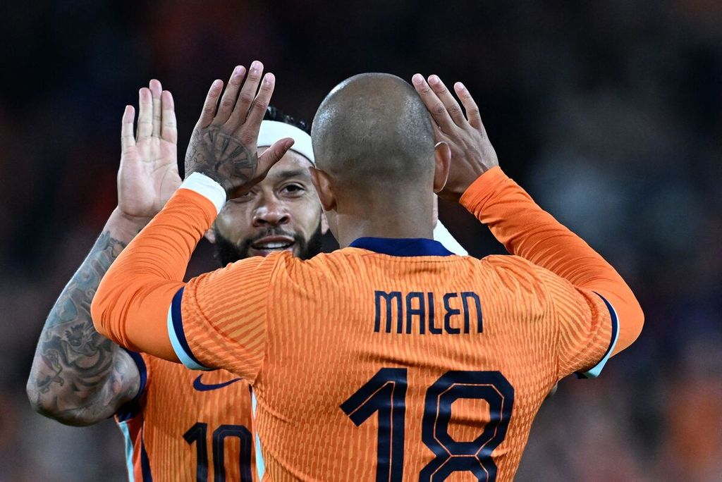 Penyerang Belanda nomor punggung 18, Donyell Malen (kanan), merayakan gol ketiga timnya bersama penyerang Belanda nomor 10, Memphis Depay (kiri), pada persahabatan internasional antara Belanda dan Eslandia di Stadion Feyenoord, Rotterdam, pada 10 Juni 2024.