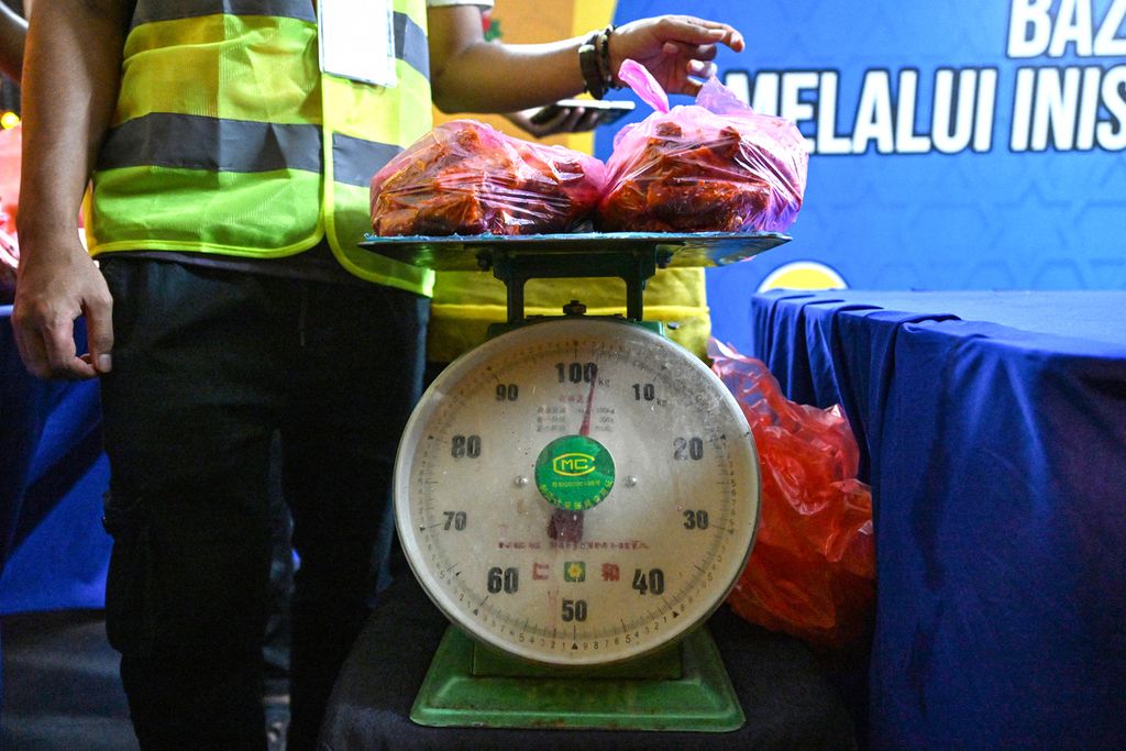 Sukarelawan dari LSM GEMA Malaysia menimbang makanan yang tidak terjual, yang dikumpulkan dari pasar, sebelum dibagikan kepada orang-orang yang membutuhkan di lingkungan Kampung Baru, Kuala Lumpur, Malaysia, selama bulan suci Ramadhan, 18 Maret 2024.