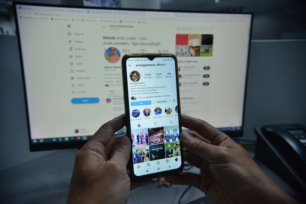 Warga membuka akun Instagram Ketua Umum Partai Golkar Airlangga Hartarto dengan latar belakang akun Twitter Wali Kota Surakarta Gibran Rakabuming Raka di Palmerah Selatan, Jakarta, Sabtu (20/05/2023).